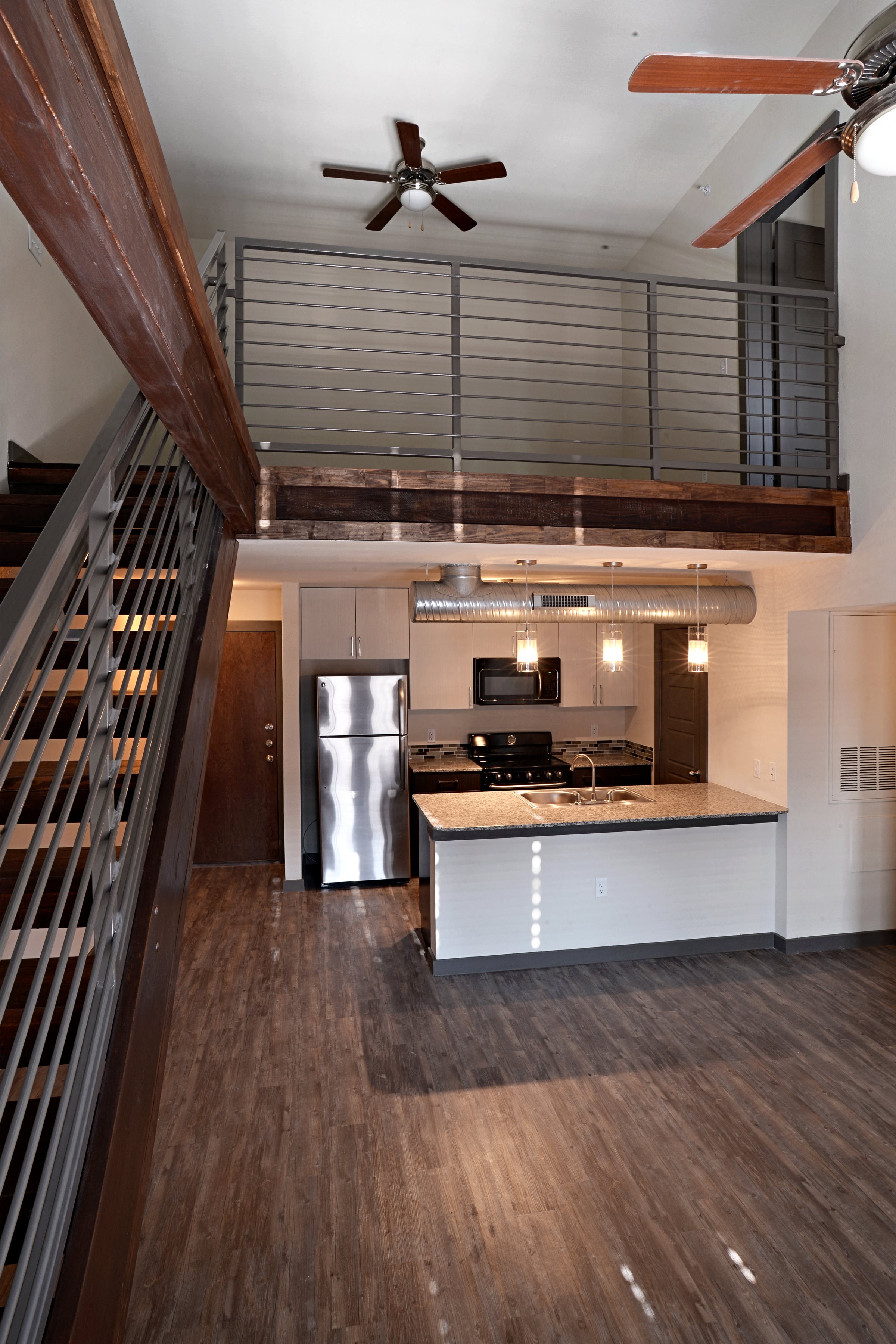 Kitchen with wooden cabinets at East End Lofts at the Railyard Apartments, Denton